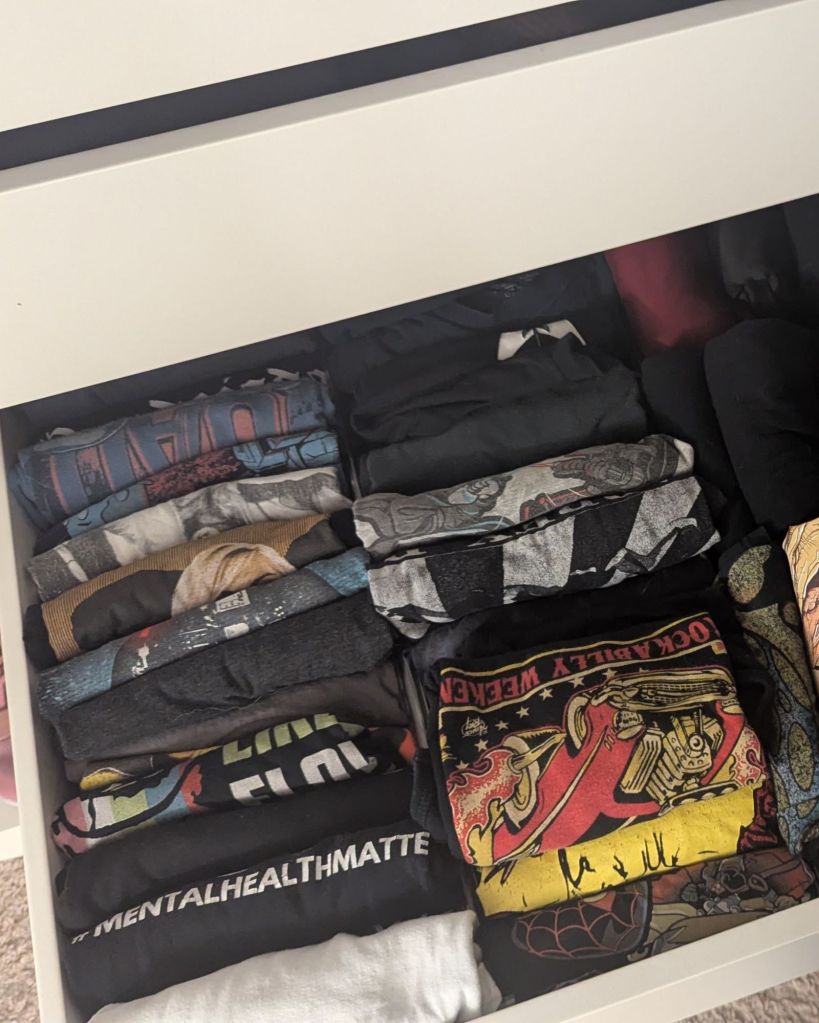 Expandable drawer dividers organizing folded graphic t-shirts vertically