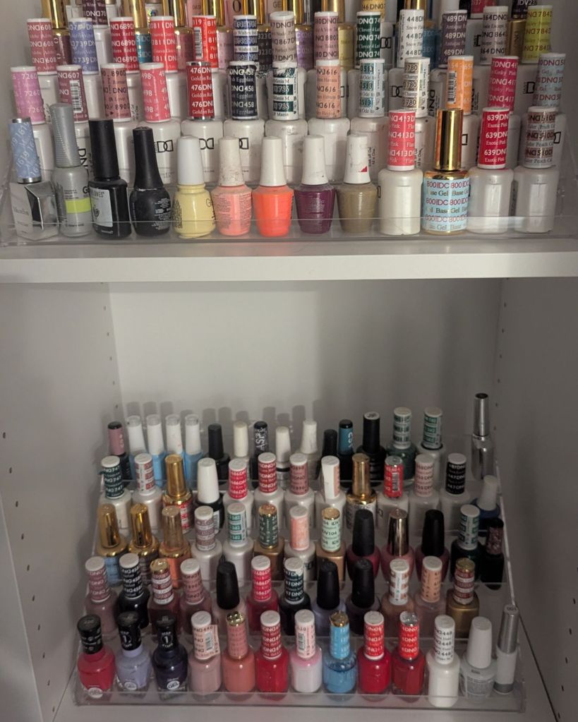Tiered acrylic organizer displaying rows of nail polish bottles on closet shelf
