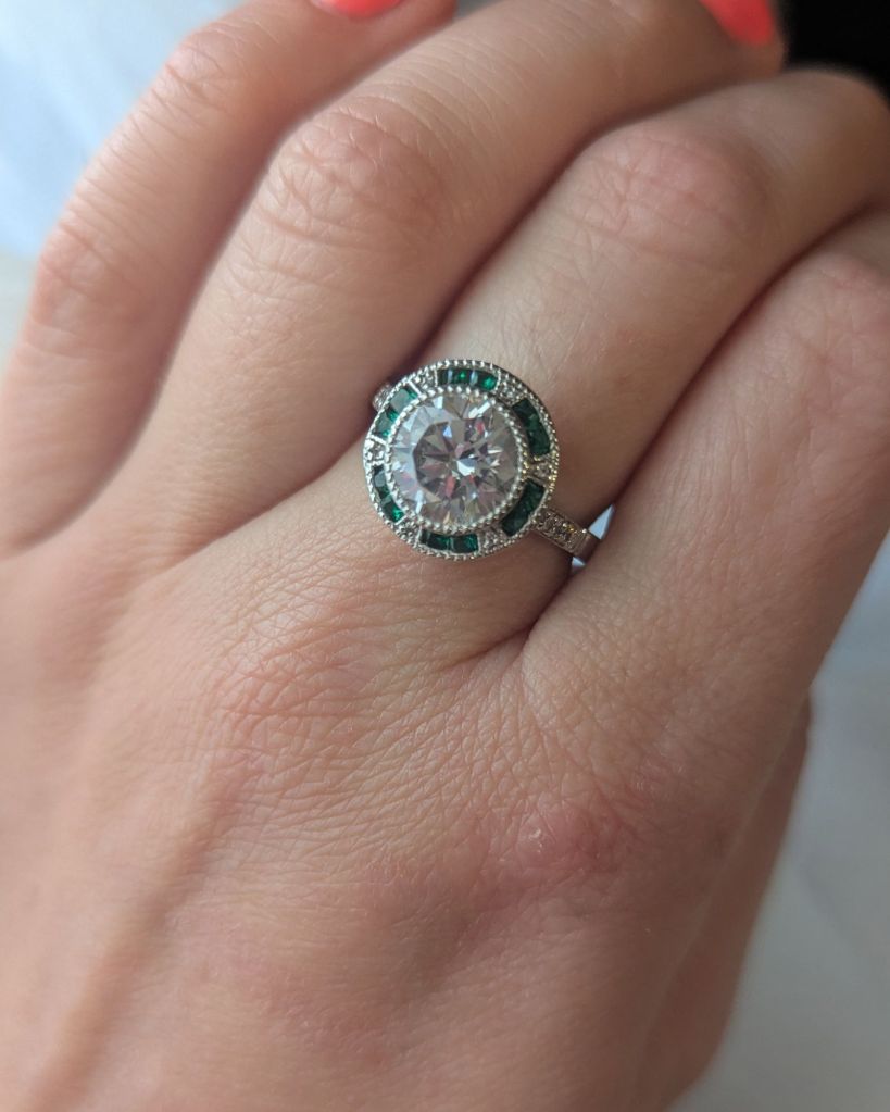 1890s inspired Art Deco ring with emeralds and diamond halo setting