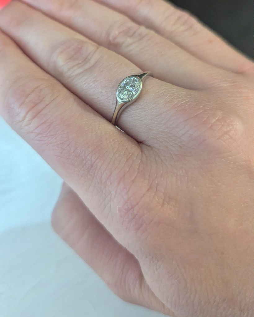 East West moissanite ring in gold bezel setting