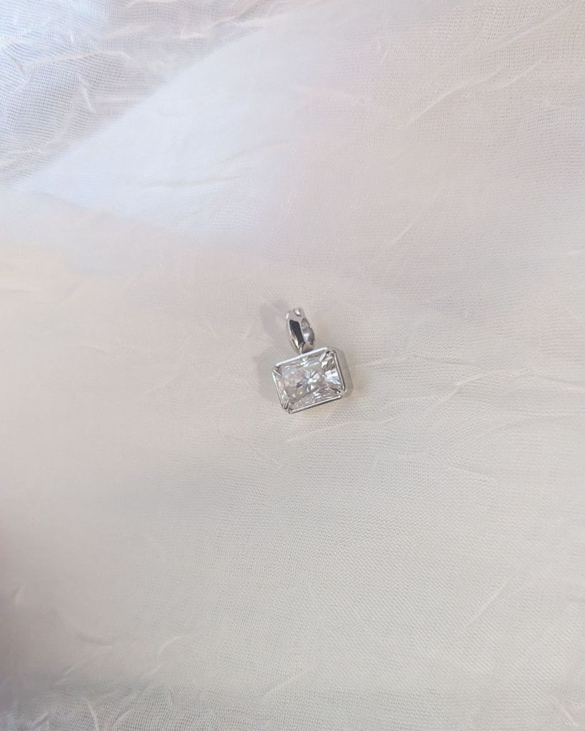 Radiant cut moissanite pendant on white fabric
