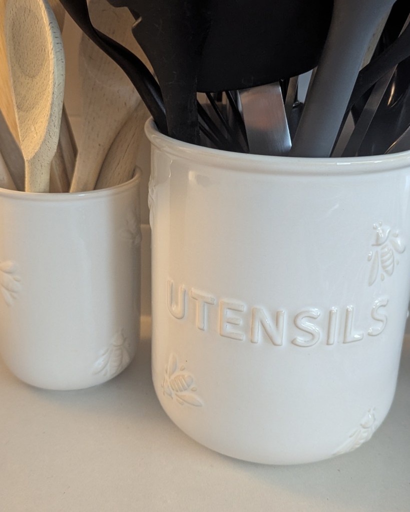 White ceramic utensil crocks with bee embossing